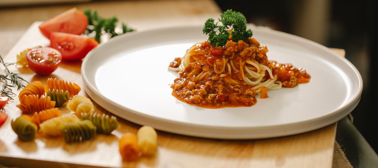 Close-up of delicious spaghetti bolognese with fresh tomatoes and herbs.